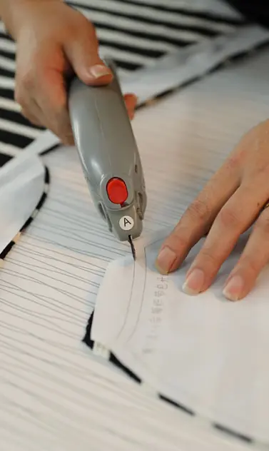 Garment technician measuring a paper pattern during clothing sample development