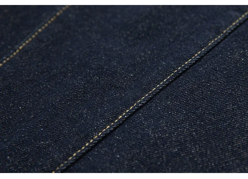 Close-up of dark indigo denim fabric with contrast topstitching