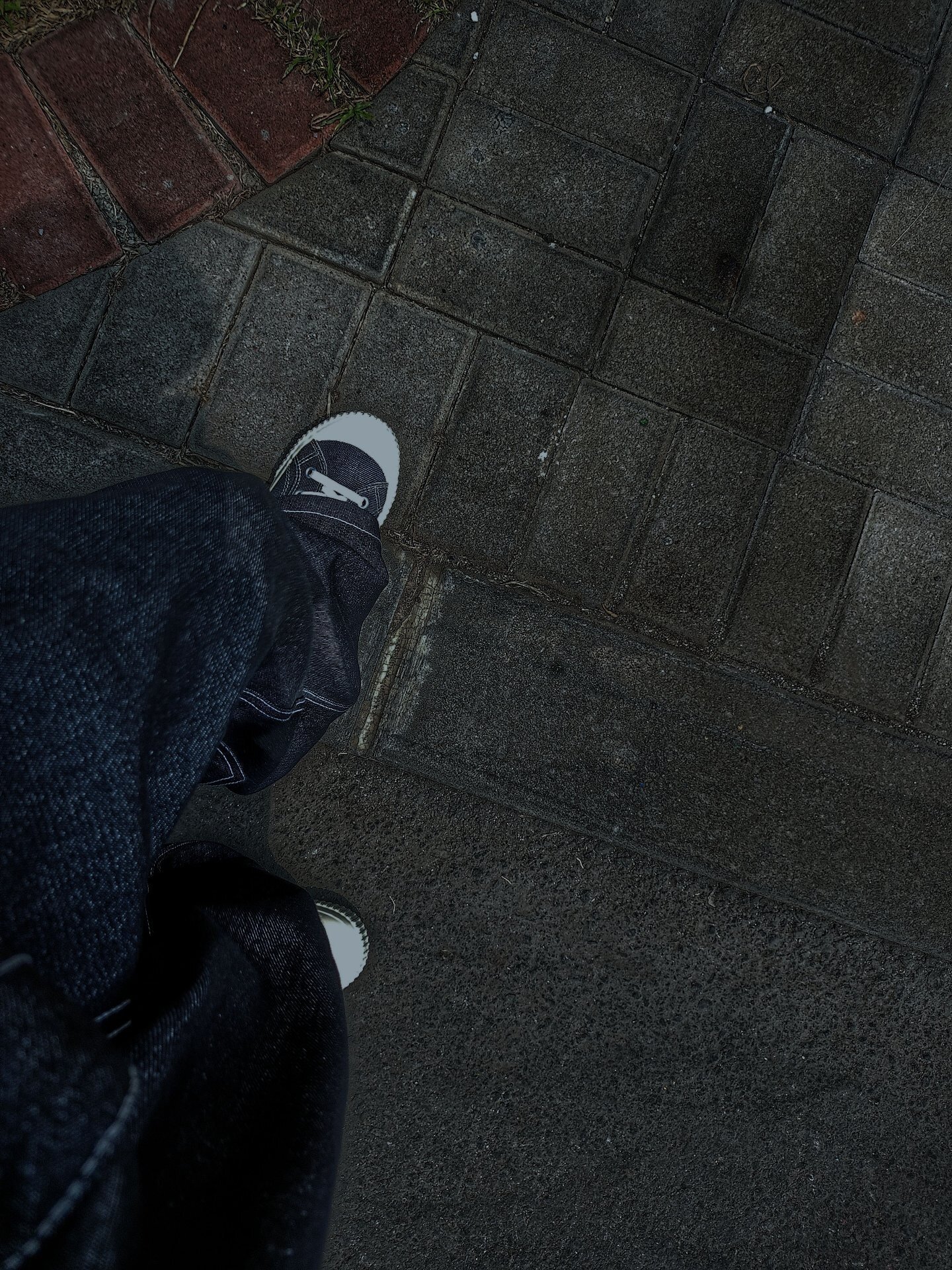 Dark indigo jeans styled with canvas sneakers, street style photo