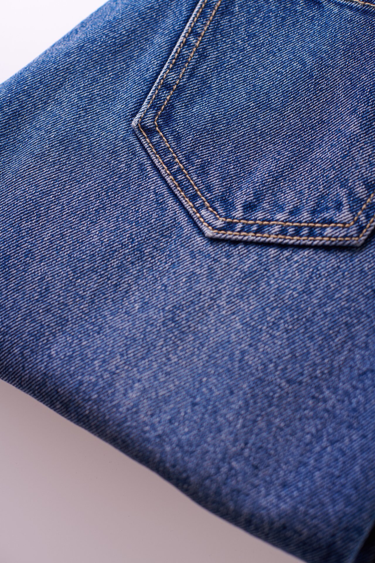 Medium blue denim back pocket with double-needle topstitching detail