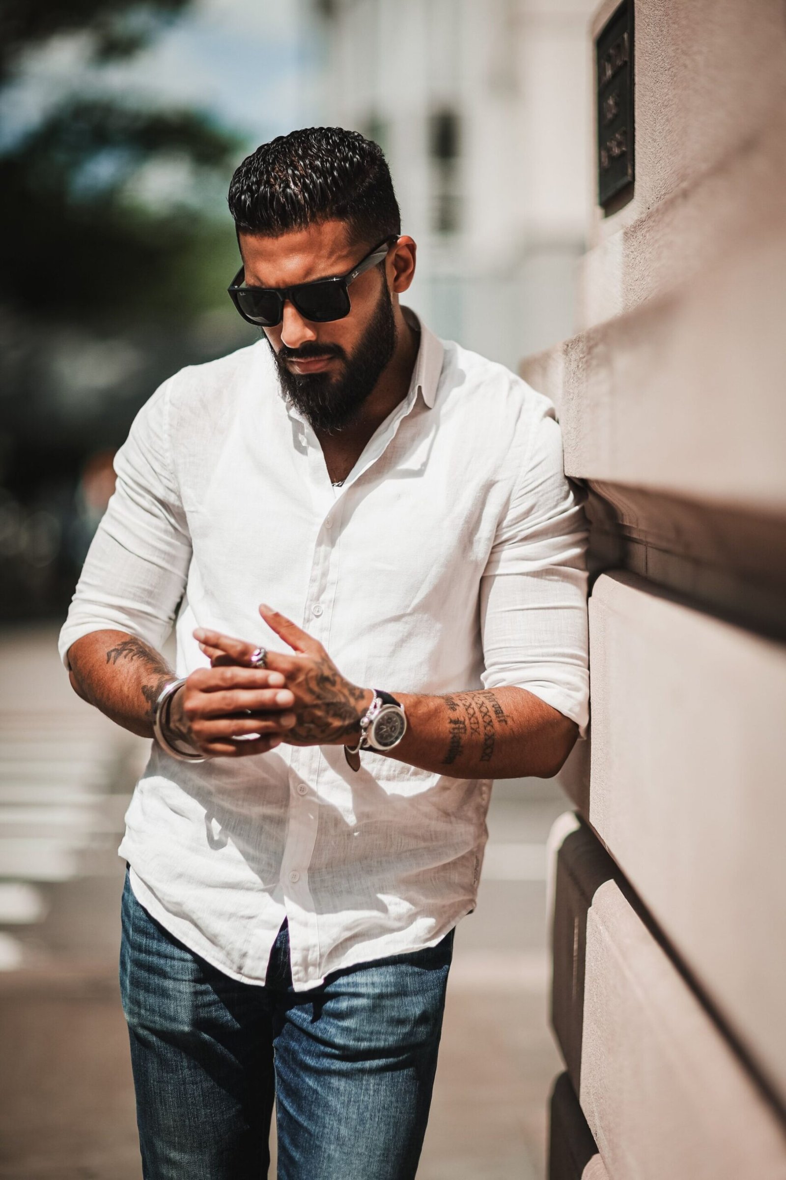 Men's white long-sleeve shirt styled with dark jeans for a casual menswear look
