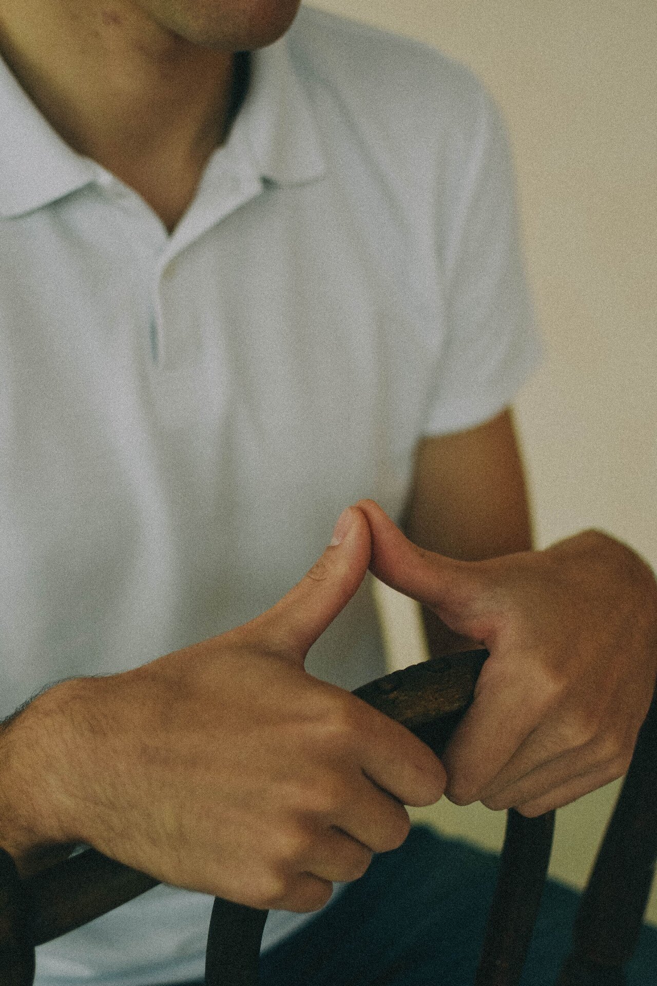 Close-up of white polo shirt collar, placket and button stitching detail