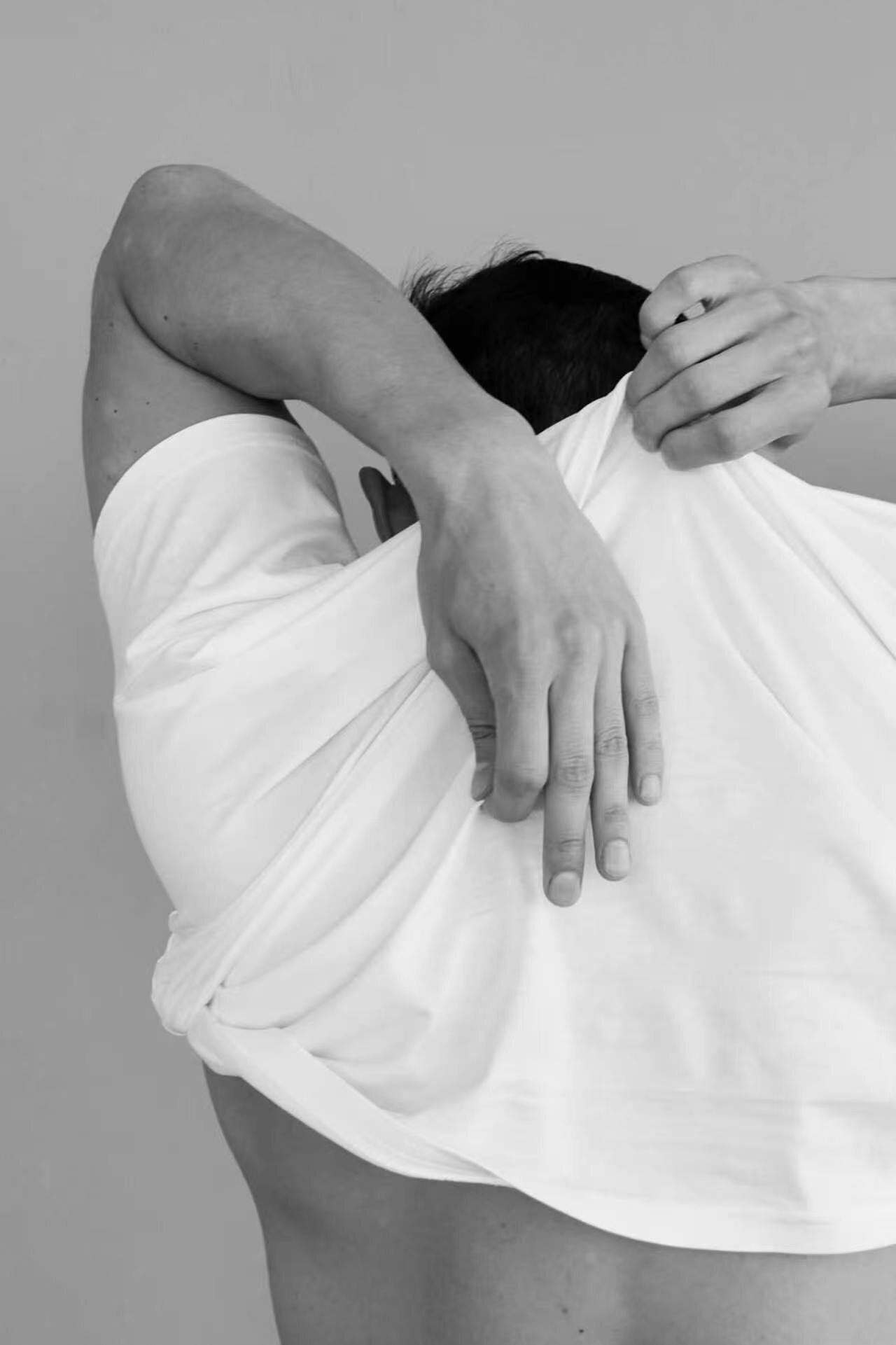 Black and white editorial photo showing white t-shirt fabric drape and fit detail
